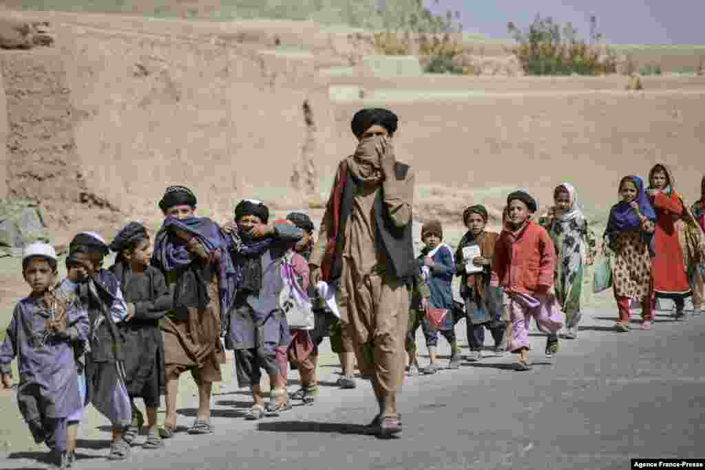 School children return to their homes after school, along a roadside at Sperwan village in Panjwai district, Afghanistan.