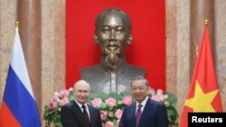 20일 블라디미르 푸틴(왼쪽) 러시아 대통령과 또 럼 베트남 국가주석이 하노이 주석궁에서 악수하고 있다. 