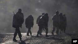 FILE - Armenian soldiers walk along a road near the border between Nagorno-Karabakh and Armenia, Nov. 8, 2020. 