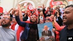 Wafuasi wa Rais wa Tunisia Kais Saied wakifanya maandamano kwenye barabara ya Avenue Habib Bourguiba kuunga mkono hatua za rais dhidi ya kuingiliwa na mataifa ya kigeni, katika mji mkuu wa Tunis, Jumapili, Mei 19, 2024. (AP).
