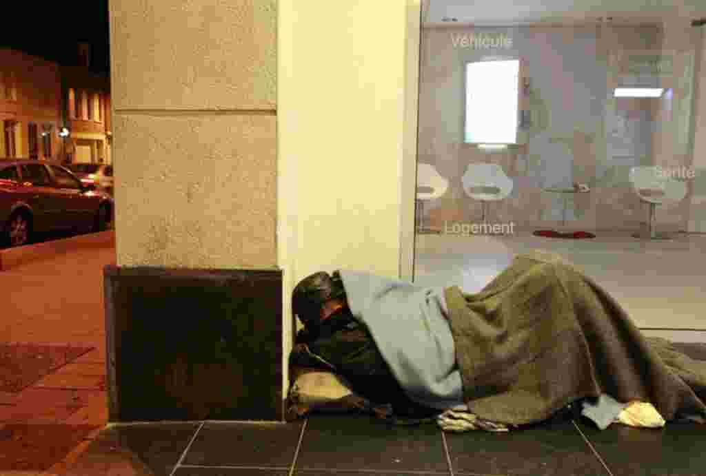 Joseph, a 51-year-old homeless man, sleeps outside a bank in Cambrai as freezing winter temperatures hit the country, February 2, 2012. (Reuters)