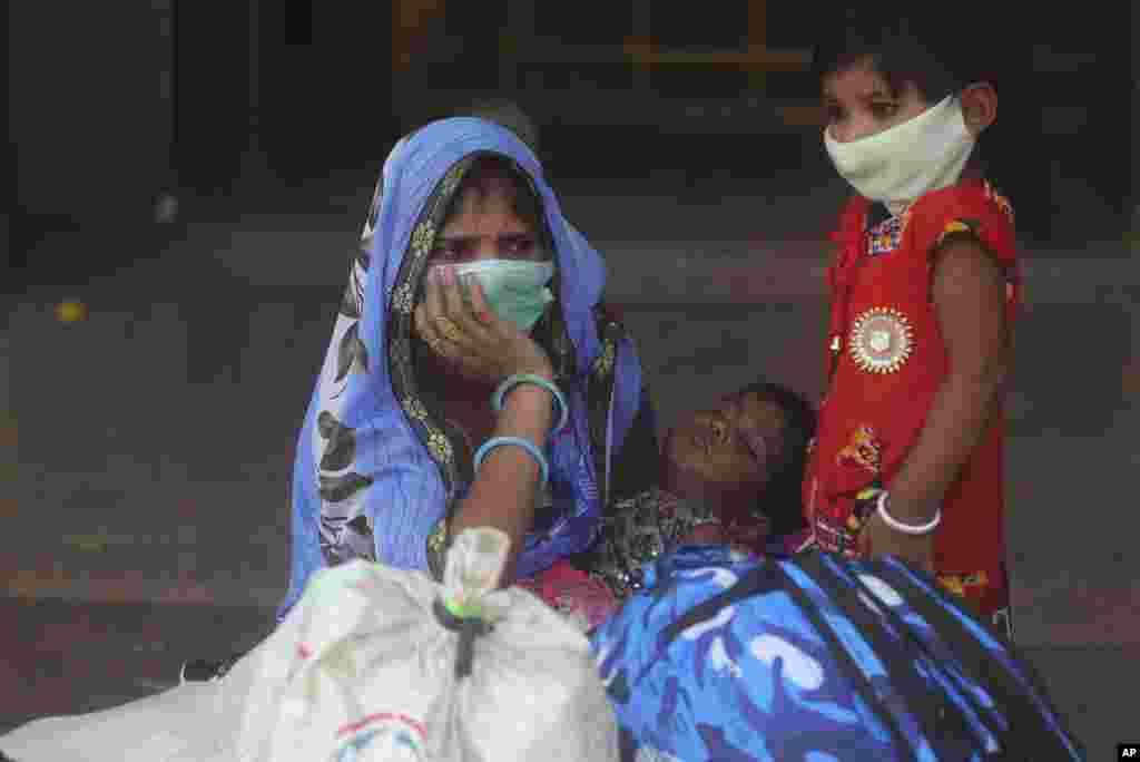 A woman and her children wait for a train at Lokmanya Tilak Terminus in Mumbai, India.