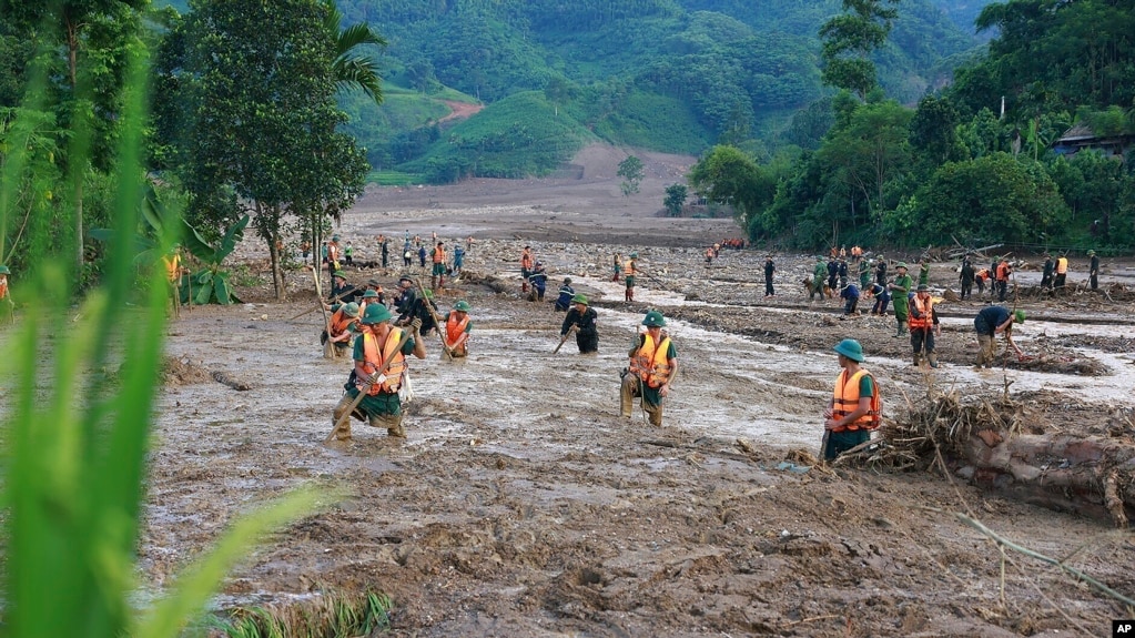 Các nhân viên cứu hộ tìm người mất tích sau một trận lũ quét ở Lào Cai.