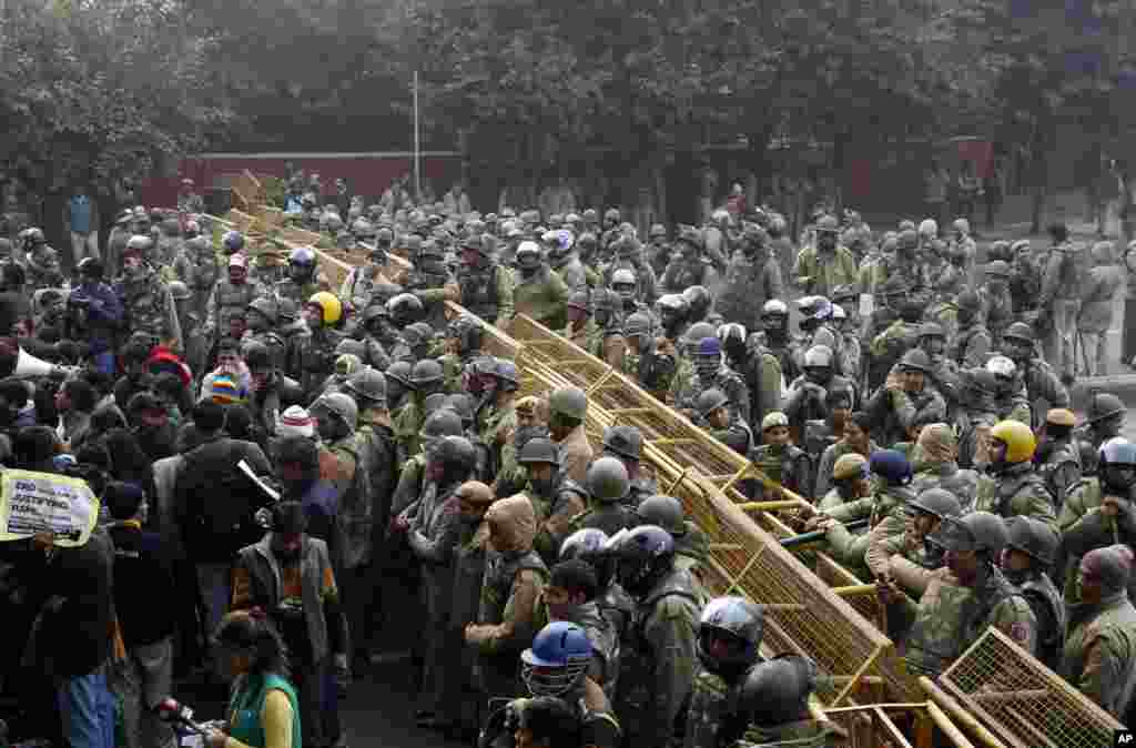 Police stand near barricades as they prepare to stop protesters on their way to India Gate while demonstrating against the gang-rape of a young woman in a moving bus in New Delhi, India, December 27, 2012. 