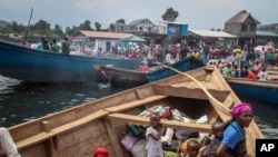 Residents board boats to flee across Lake Kivu in the direction of South Kivu province, at the port of Kituku in Goma, in eastern Congo, May 28, 2021.