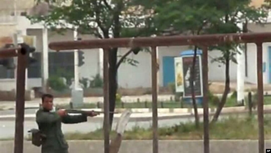 An image grab taken from a video posted on YouTube, May 20, 2011, shows a Syrian soldier pointing his rifle and firing at anti-regime protesters during a demonstration in Hama, north of Damascus