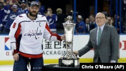 Kapiten Vašington Kapitalsa Aleks Ovečkin pozira uz trofej Princa od Velsa, namenjenog šampionu Istočne konferencije NHL-a. Desno je zamenik komesara NHL-a Bil Dejli (Foto: AP/Chris O'Meara))