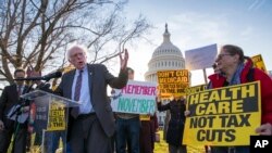 Sen. Bernie Sanders, I-Vt., joins protesters outside the Capitol as Republicans in the Senate work to pass their sweeping tax bill, a blend of generous tax cuts for businesses and more modest tax cuts for families and individuals, on Capitol Hill in Washington, Thursday, Nov. 30, 2017.