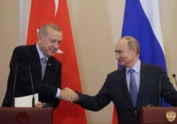 FILE - Russian President Vladimir Putin, right, and Turkish President Recep Tayyip Erdogan shake hands after their joint news conference following their talks in the Bocharov Ruchei residence in the Black Sea resort of Sochi, Russia, Oct. 22, 2019.