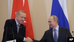 FILE - Russian President Vladimir Putin and Turkish President Recep Tayyip Erdogan shake hands after their joint news conference following their talks at the Bocharov Ruchei residence in the Black Sea resort of Sochi, Russia, Oct. 22, 2019. 