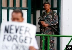 A soldier watches demonstrators protest President Rodrigo Duterte's Martial Law declaration for the southern Mindanao region, July 7, 2017, outside of the Philippine armed forces headquarters in Quezon city northeast of Manila, Philippines.