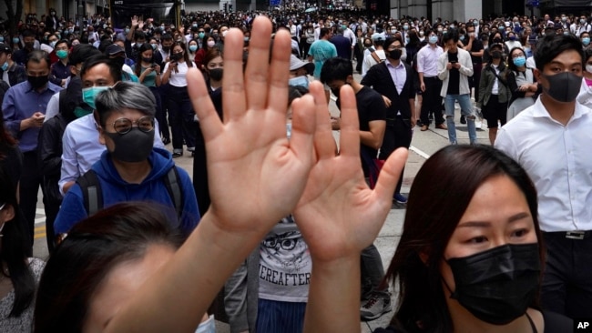 香港民众在中环举行抗议时举手表达“五项诉求缺一不可”。（2019年11月12日）