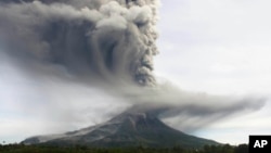 Gunung Sinabung memuntahkan abu vulkanik setinggi delapan kilometer, terlihat dari kawasan Tiga Pancur, Sumatra Utara (18/11).