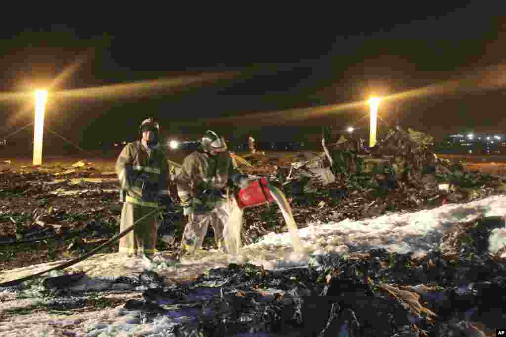 In this photo provided by Russian Emergency Situations Ministry, fire fighters and rescuers work at the crash site of a Russian passenger airliner near Kazan, the capital of the Tatarstan republic, about 720 kilometers (450 miles) east of Moscow, Nov. 17, 2013. The airliner crashed while trying to land at the airport in the city of Kazan, killing all people aboard, officials said.