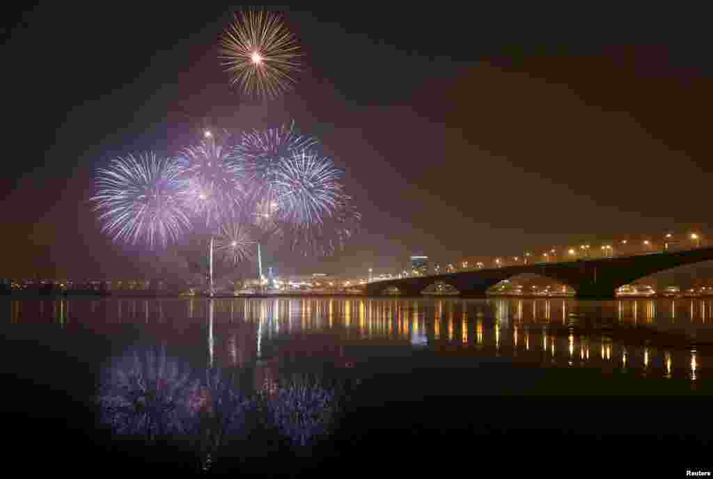 Fireworks are reflected in the waters of the Yenisei River during a ceremony to open the city&#39;s Christmas and New Year tree in Krasnoyarsk, Russia. Picture taken with long exposure.