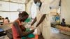 Une mère tient dans ses bras sa fille d'un an souffrant de malnutrition sévère alors qu'elle est suivie par un médecin dans un hôpital géré par Médecins Sans Frontières à Old Fangak, dans l'État de Jonglei, au Sud-Soudan, mardi 28 décembre 2021.