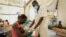 FILE: A woman's malnourished child is attended by a doctor in a hospital in Jonglei state, South Sudan Tuesday, Dec. 28, 2021. Aid groups say more will face hunger this year, because of severe floods as well as conflict and the sluggish implementation of the peace agreement.
