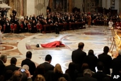 Pope Francis prostrates himself in prayer during the Good Friday Passion of Christ Mass inside St. Peter's Basilica, at the Vatican, March 30, 2018.