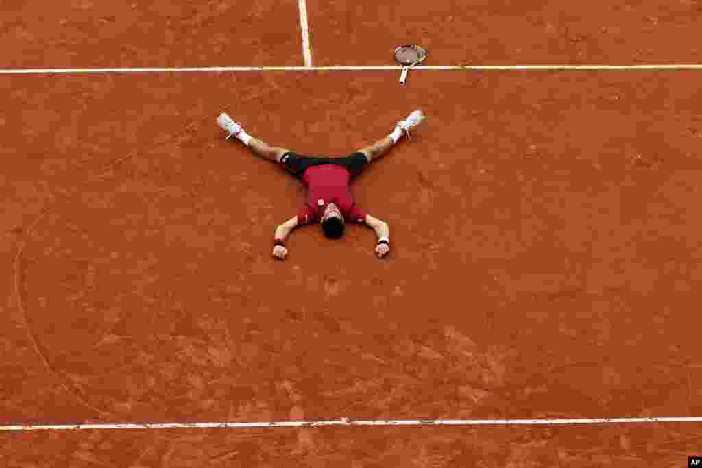 Serbia&#39;s Novak Djokovic lies on the clay after defeating Britain&#39;s Andy Murray during their final match of the French Open tennis tournament at the Roland Garros stadium, June 5, 2016, in Paris, France. Djokovic won 3-6, 6-1, 6-2, 6-4.