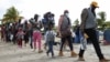 Migrantes, en su mayoría haitianos, caminan para abordar botes que los llevarán a Acandi, para cruzar a Panamá para continuar su viaje hacia Estados Unidos, en Necoclí, Colombia, el 23 de septiembre de 2021. 