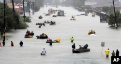 Rescue boats float on a flooded street as people are evacuated from rising floodwaters brought on by Tropical Storm Harvey on Aug. 28, 2017, in Houston.