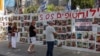 Warga Israel berdiri di depan tembok di Tel Avivdengan poster mendukung para sandera yang diculik kelompok Islam Palestina Hamas, di tengah konflik di Gaza antara Israel dan Hamas, 23 April 2024. 