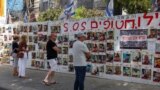  تل ابیب میں لوگ اس دیوار کے سامنے کھڑے ہیں جس پر سات اکتوبر کو اسرائیل پر حملے میں یرغمال بنائے گئے لوگوں کے پوسٹرز لگے ہیں ، فوٹو رائٹرز، 23 اپریل ۔2024