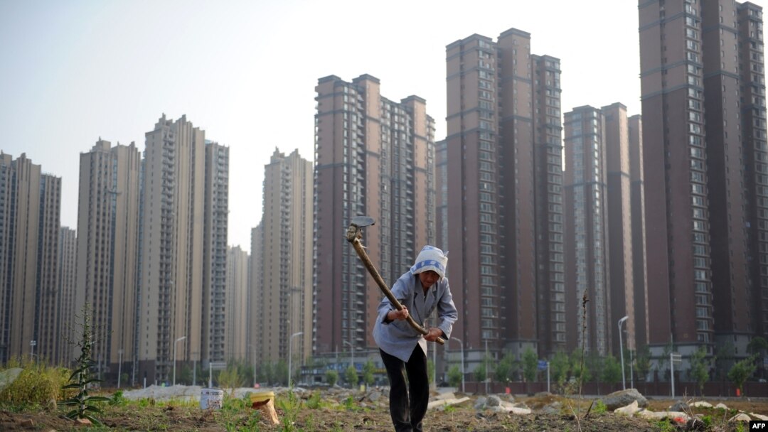 資料照：安徽省合肥一處新開發的樓盤旁，一名婦女在一小塊田地裡勞作。 （2011年5月21日）