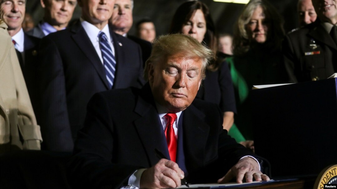 Presiden AS Donald Trump menandatangani RUU anggaran pertahanan 2020 di pangkalan udara Andrews, Maryland, Jumat (20/12). 