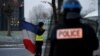 A protester wearing a yellow vest holds a French flag as the authorities dismantle their shelter at a traffic island near the A2 Paris-Brussels motorway in Fontaine-Notre-Dame, France, Dec. 14, 2018. 