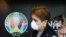Travellers pass by a logo of the 2020 UEFA European Football Championship displayed on a wall inside Bucharest Henri Coanda International Airport, in Otopeni, Romania, March 16, 2020.