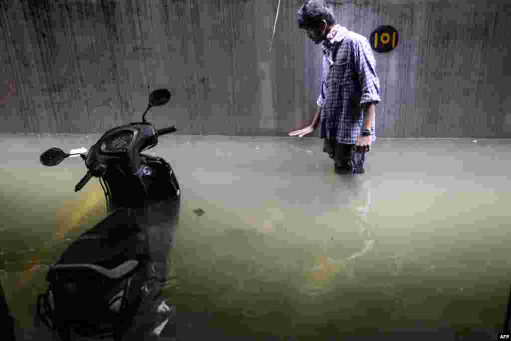 A resident surveys the level of water in his cellar area at an apartment following heavy rains in Hyderabad, India.