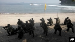 FILE - U.S. Marines from the 3rd Marine Expeditionary Brigade and the 31st Marine Expeditionary Unit and Philippine marines take their positions as they take part in a boat raid exercise during their joint military exercise, dubbed PHIBLEX 2016.