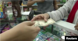 Venezolanos compran con dólares en tiendas que comercializan en la moneda estadounidense. [Foto tomada de video de Reuters de diciembre de 2019]