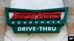 FILE - A Krispy Kreme Doughnuts sign in Miami, Aug. 11, 2017.