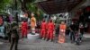 People walk past statues featuring characters from the Netflix series Squid Game at a food court to attract visitors in Surabaya on Oct. 21, 2021.