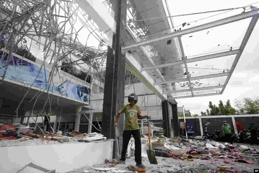ایک امدادی اہلکار جزیرہ بالی میں زلزلے سے متاثر ہونے والی عمارت کا ملبہ صاف کر رہا ہے۔