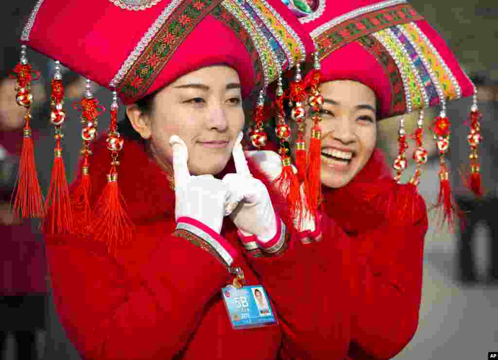 Hostesses pose for photos outside the Great Hall of the People during the opening session of the annual National People&#39;s Congress in Beijing, China.