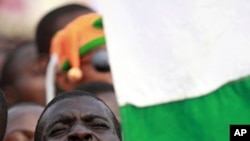 A supporter of Ivory Coast's incumbent leader Laurent Gbagbo sings the national anthem during a rally in Abidjan, 29 Dec 2010