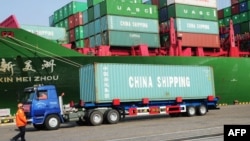 A truck transporting a container leaves the port of Qingdao, in northeast China's Liaoning province, Jan. 20, 2014.
