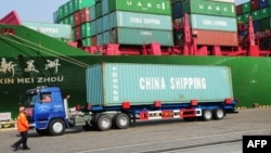 A truck transporting a container leaves the port of Qingdao, in northeast China's Liaoning province, Jan. 20, 2014.