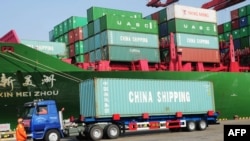 Click to enlarge--A truck transporting a container leaves the port of Qingdao, in northeast China.