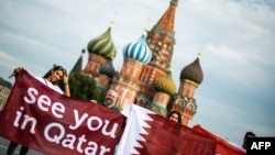 Sekelompok orang di Lapngan Merah di Moskow, membentangkan spanduk bertuliskan “Sampai Jumpa di Qatar” merujuk pada Piala Dunia 2022 di Qatar, pada malam pertandingan final Piala Dunia 2018 antara Perancis dan Kroasia, 14 Juli 2018.
