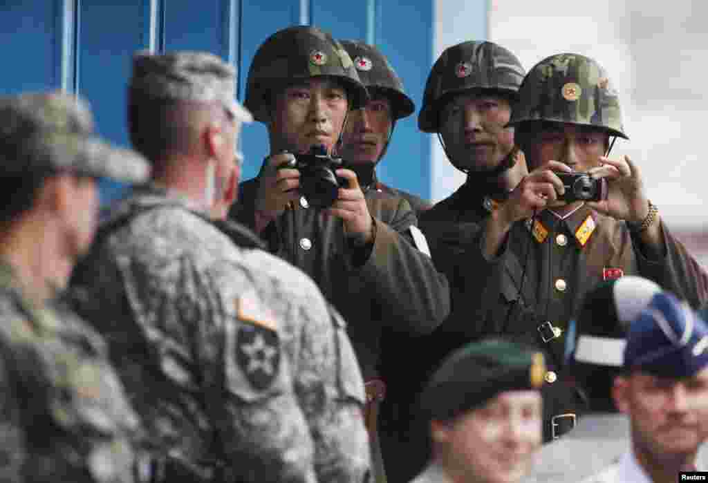 27일 한국전 정전 60주년을 맞아 판문점 남측 지역에서 기념식이 열린 가운데, 북측 북한 병사들이 기념식 장면을 촬영하고 있다.