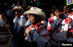 Members of the Huichol indigenous community, wearing Aztec traditional costumes, take part in a protest in Mexico City, Oct. 27, 2011.