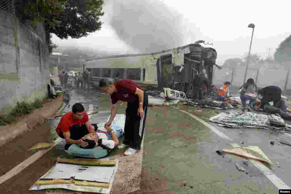 Victims receive help after a train crashed near Santiago de Compostela, northwestern Spain, July 24, 2013. At least 77 people died and score more were injured.