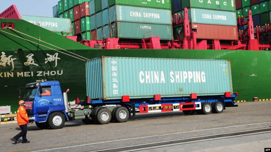 FILE - A truck transporting a container leaves the port of Qingdao, in northeast China's Liaoning province.