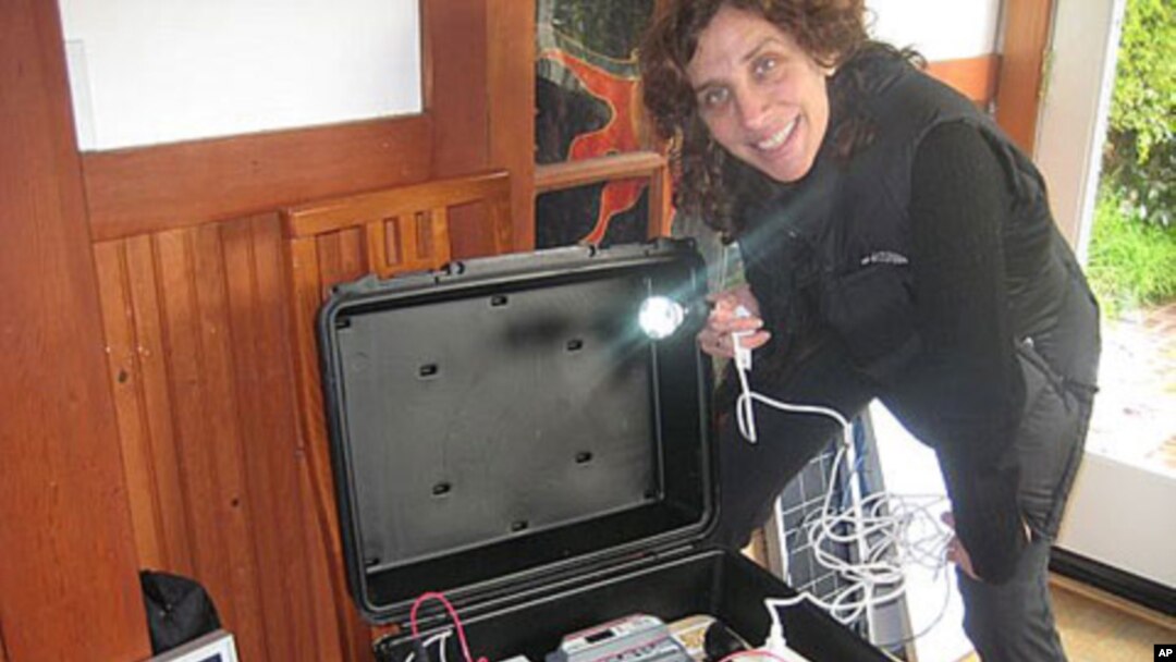 Dr. Laura Stachel with a 'solar suitcase,' which powers two overhead LED lighting, charges walkie-talkies and cell phones and includes LED headlamps that come with their own rechargeable batteries.