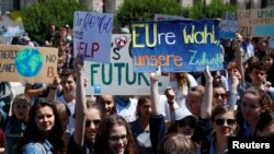 Para pemuda mengacungkan poster dalam mogok sekolah menuntut aksi pengurangan perubahan iklim di Heldenplatz, Wina, Austria, 24 Mei 2019. 