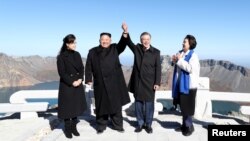 South Korean President Moon Jae-in and North Korean leader Kim Jong Un pose for photographs on the top of Mt. Paektu, North Korea, Sept. 20, 2018.